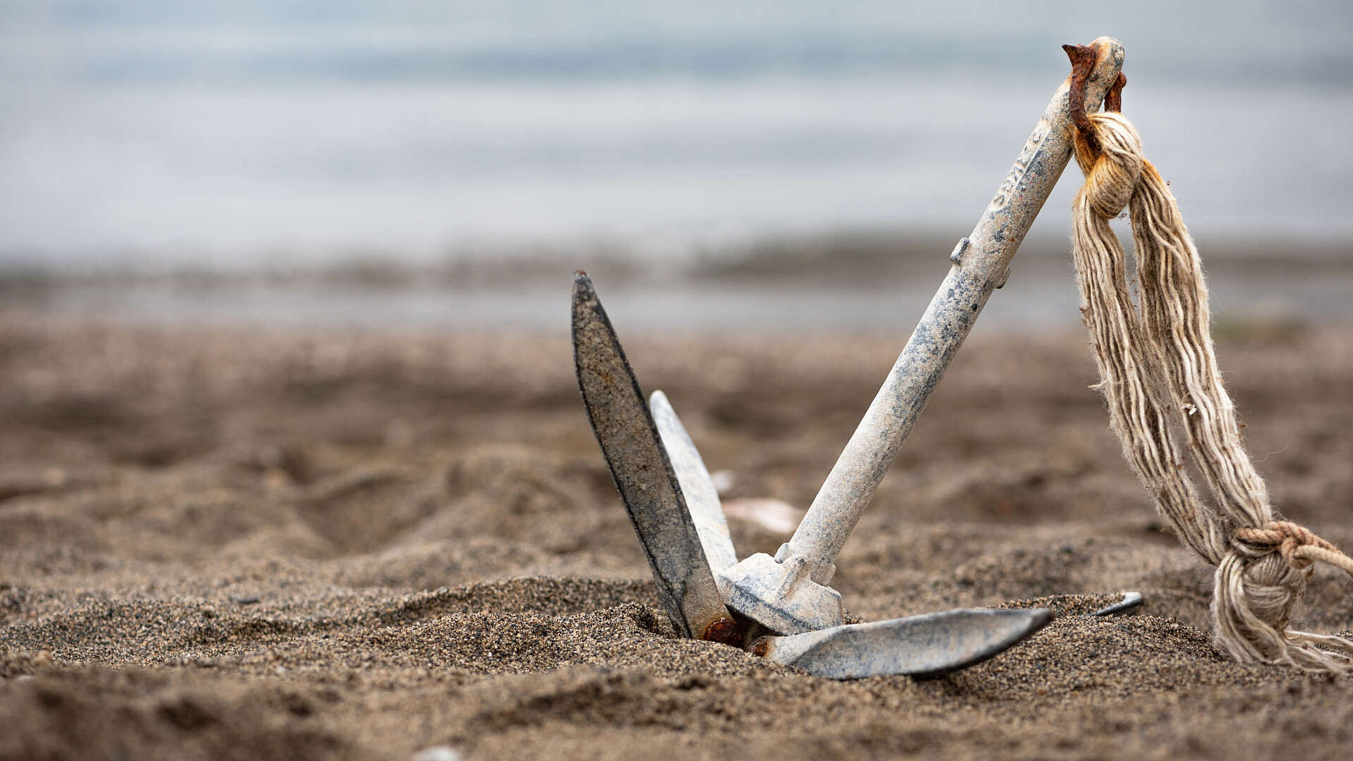 Ein Anker am Strand als Symbol für Unterstützung